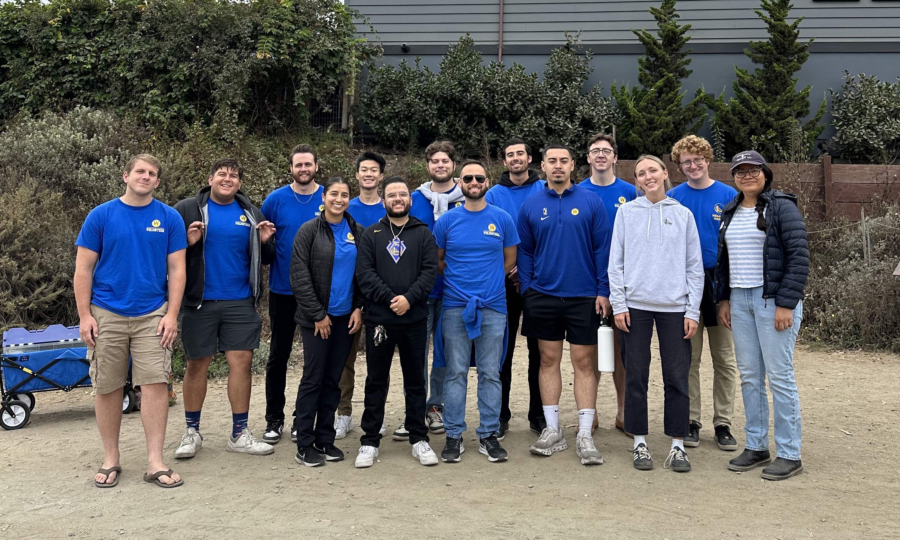 Warriors employees standing in front of a garden smiling at the camera.