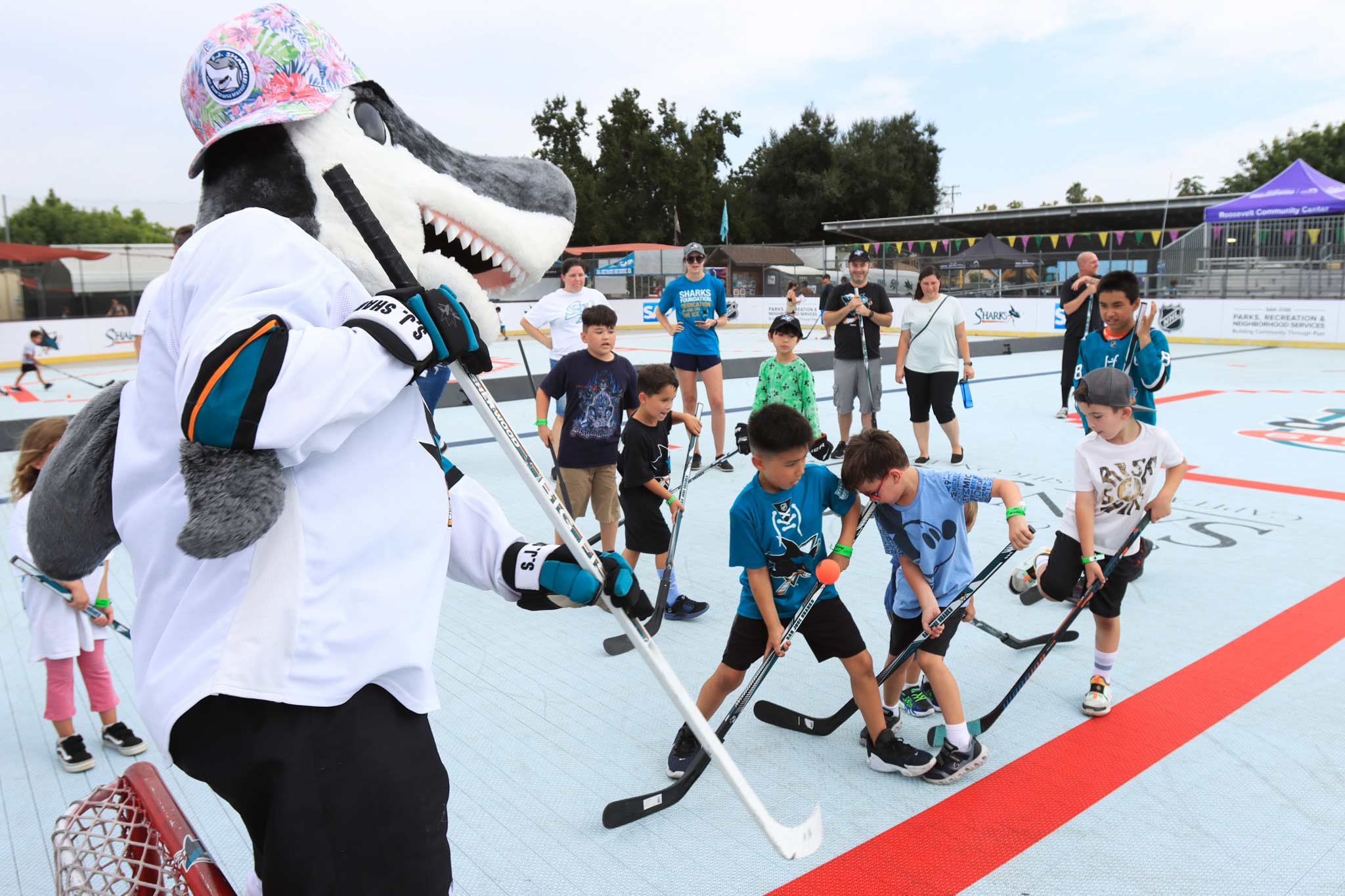 Kids playing street hockey with the Sharks mascot