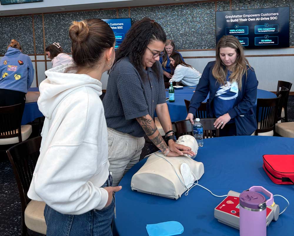 Three women practicing CPR on a dummy during a training session