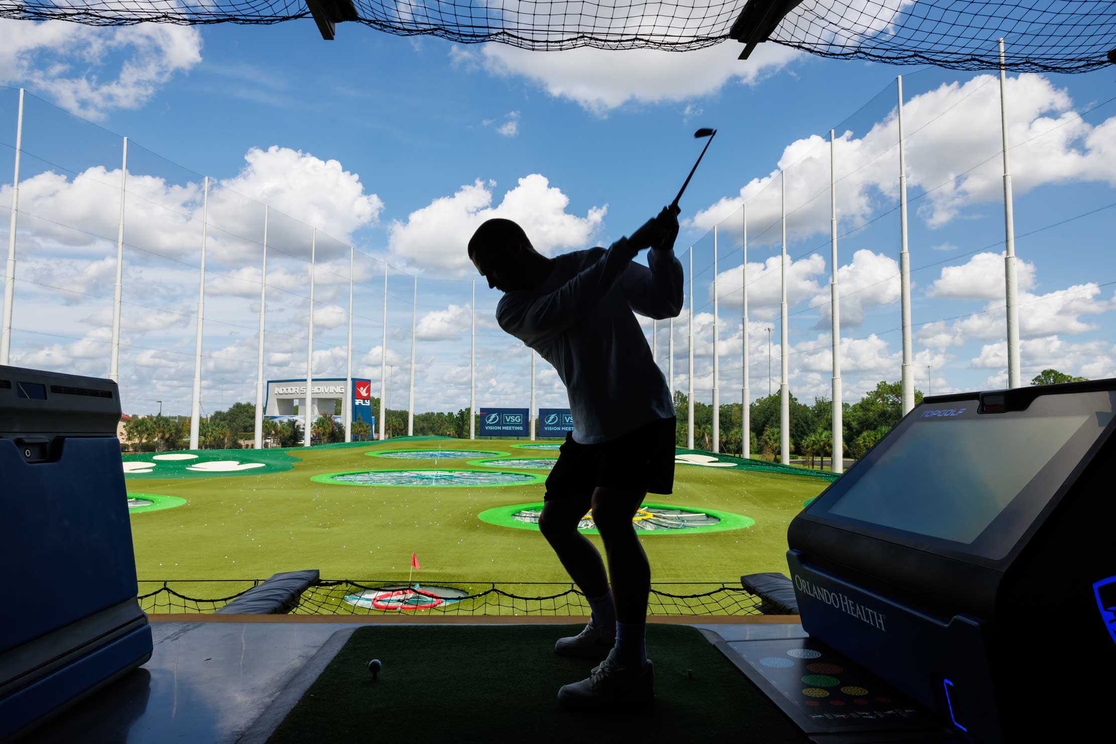 A man taking a golf swing at a putting green